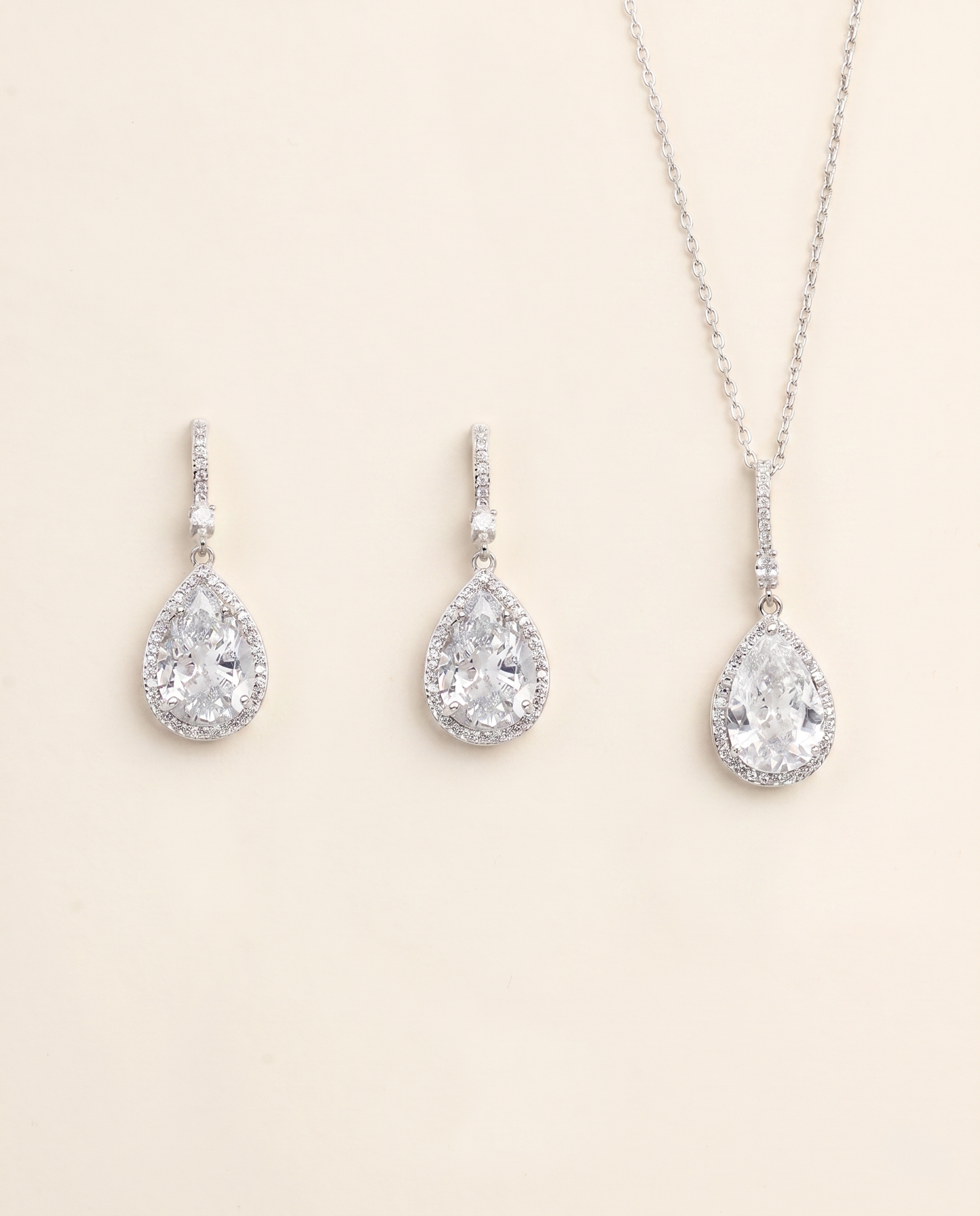 A necklace and earrings set made of silver and crystal materials.