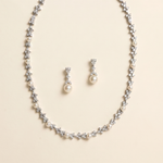 A necklace and earrings set made of silver and white pearls and diamonds.