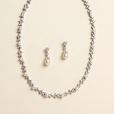 A necklace and earrings set made of silver and white pearls and diamonds.