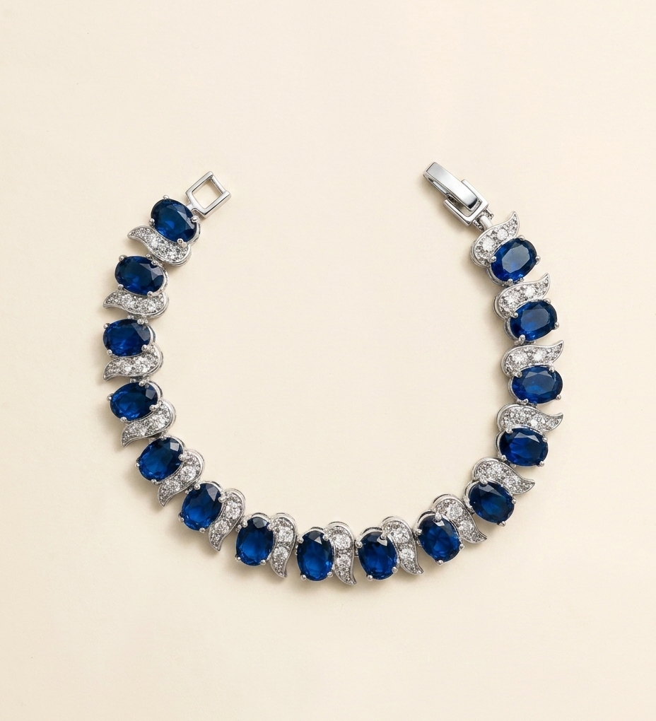 A bracelet with a row of blue sapphires and diamonds set in silver.