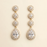 A pair of elegant gold earrings with a row of small, round diamonds set in the center of each pendant.