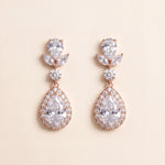 A pair of elegant earrings with large, clear gemstones set in a delicate, ornate design.