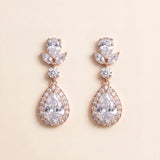 A pair of elegant earrings with large, clear gemstones set in a delicate, ornate design.
