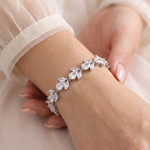 A close-up image of a person's hand wearing a bracelet with a row of small, clear gemstones.