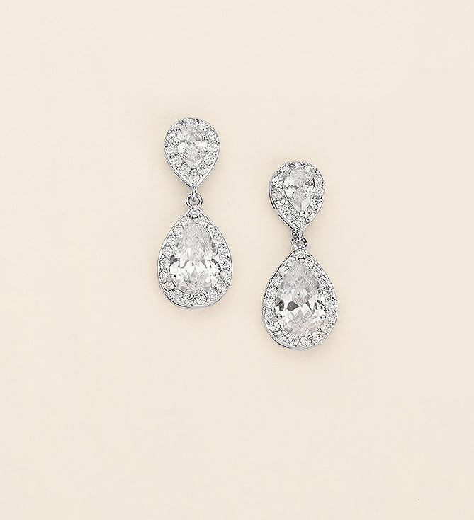 a pair of diamond earrings on a white background