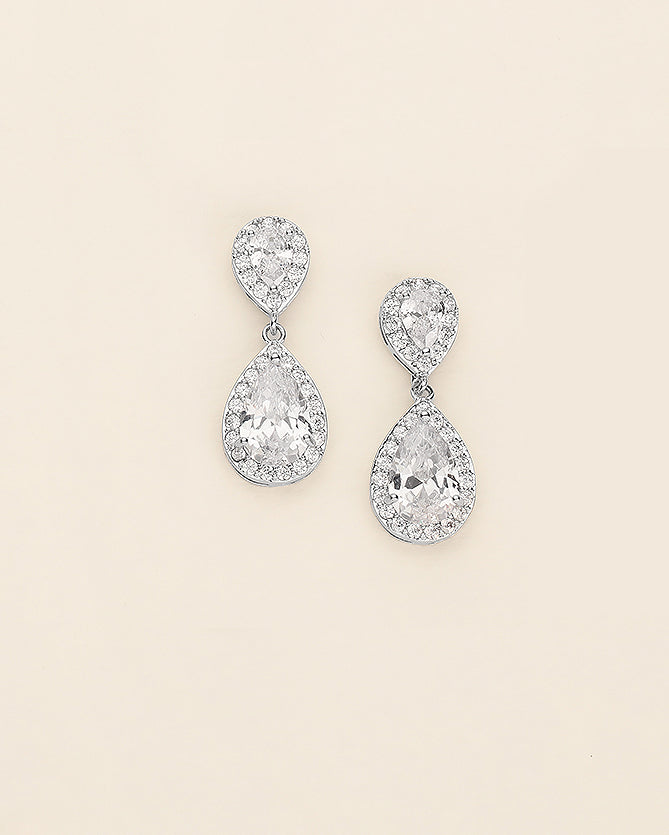 a pair of diamond earrings on a white background