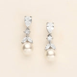 a pair of pearl and diamond earrings