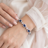 A close-up image of a person's hand wearing a bracelet with blue gemstones.