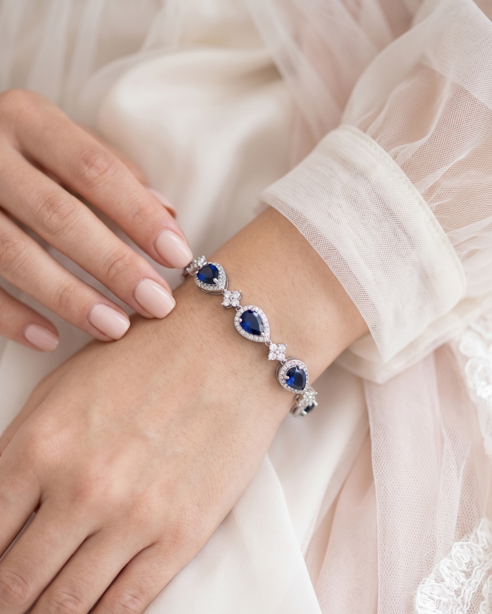 A close-up image of a person's hand wearing a bracelet with blue gemstones.