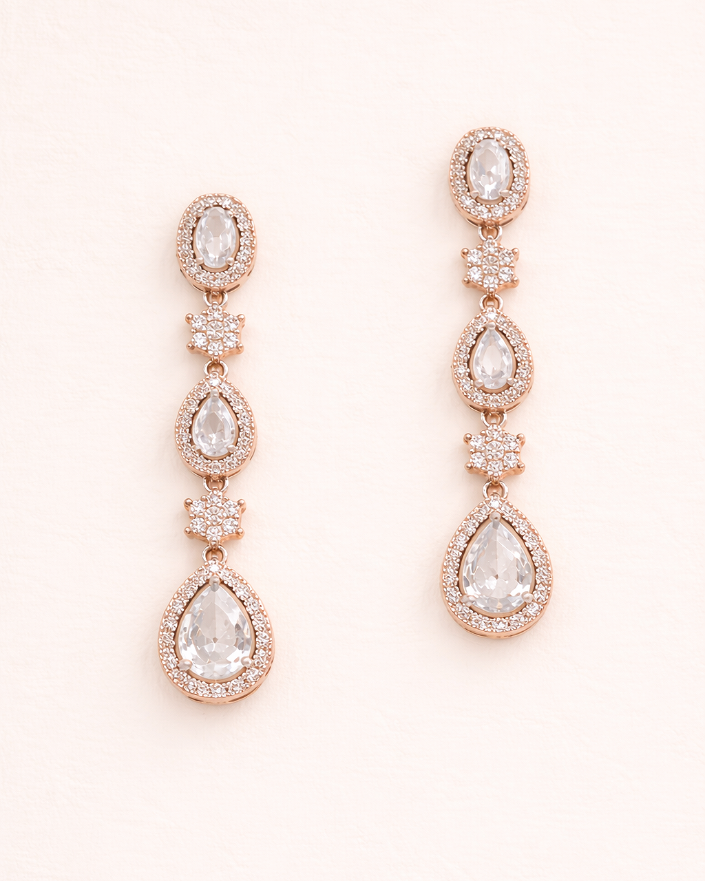 A pair of elegant gold earrings with clear gemstones, featuring a row of three stones on each earring.
