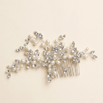 A decorative hair accessory with a combination of pearls, crystals, and branches.