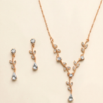 A delicate gold necklace and earrings set adorned with small, clear gemstones.
