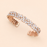 A delicate gold bracelet adorned with numerous small, clear gemstones.
