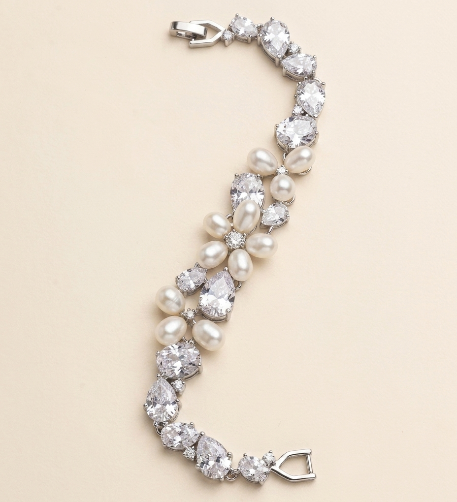 A bracelet made of pearls and diamonds, with a clasp at the end, is displayed against a light beige background.