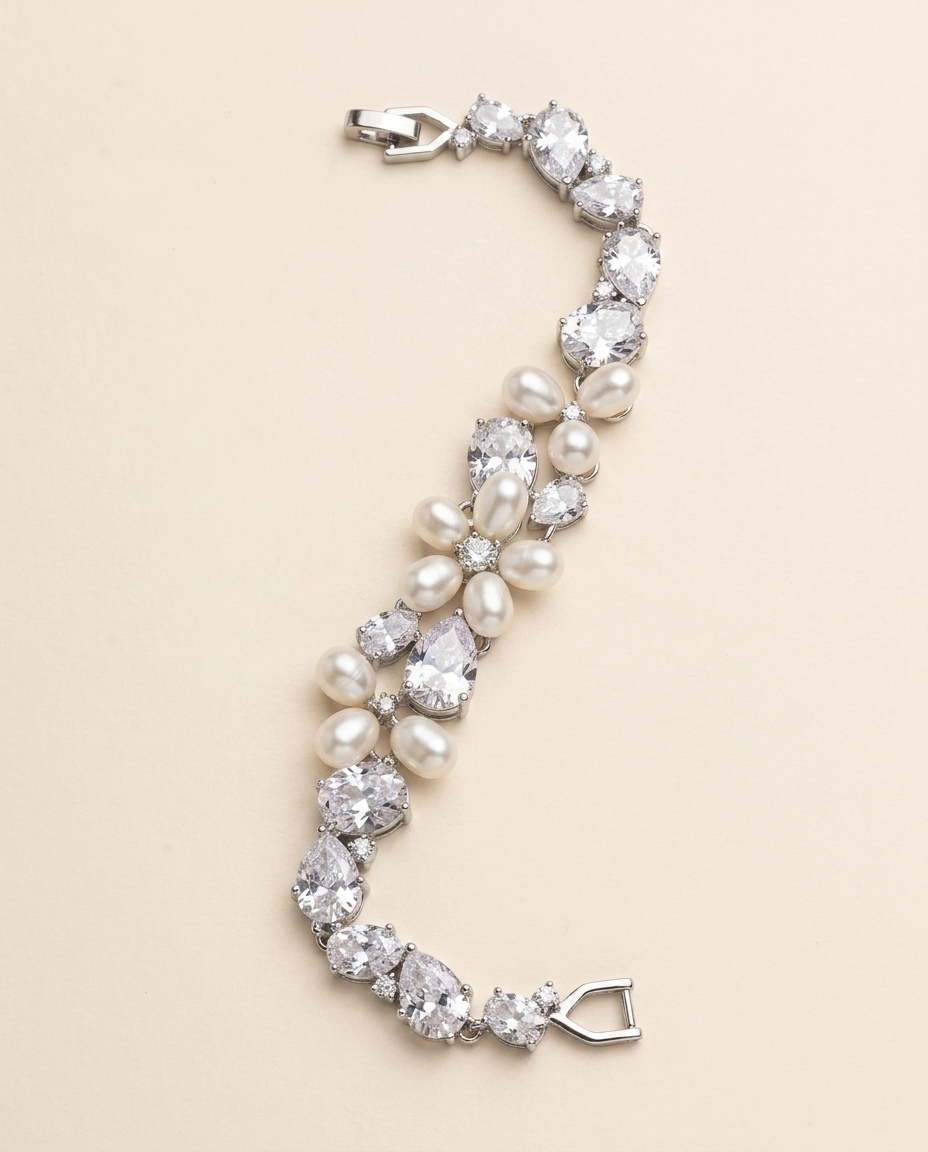 A bracelet made of pearls and diamonds, with a clasp at the end, is displayed against a light beige background.