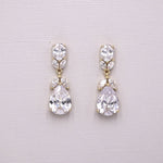 A pair of elegant earrings with large, clear gemstones set in a gold-colored metal.