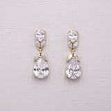 A pair of elegant earrings with large, clear gemstones set in a gold-colored metal.