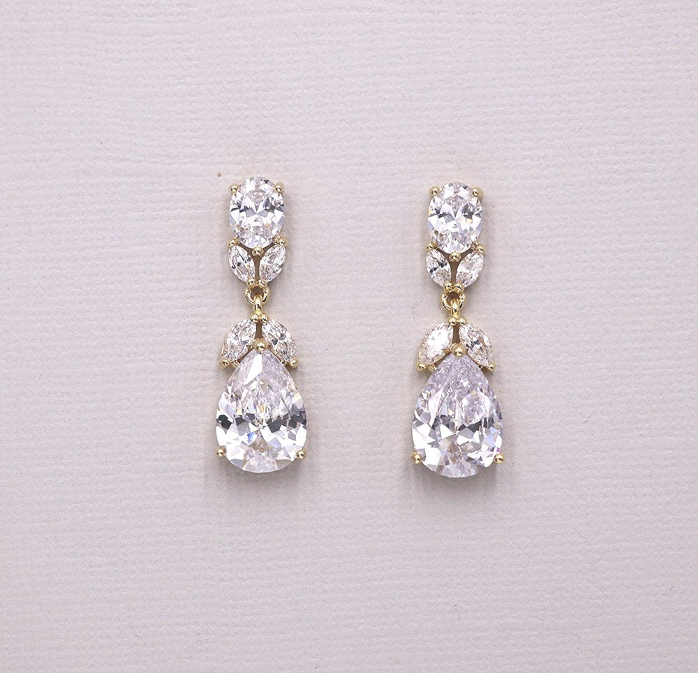 A pair of elegant earrings with large, clear gemstones set in a gold-colored metal.