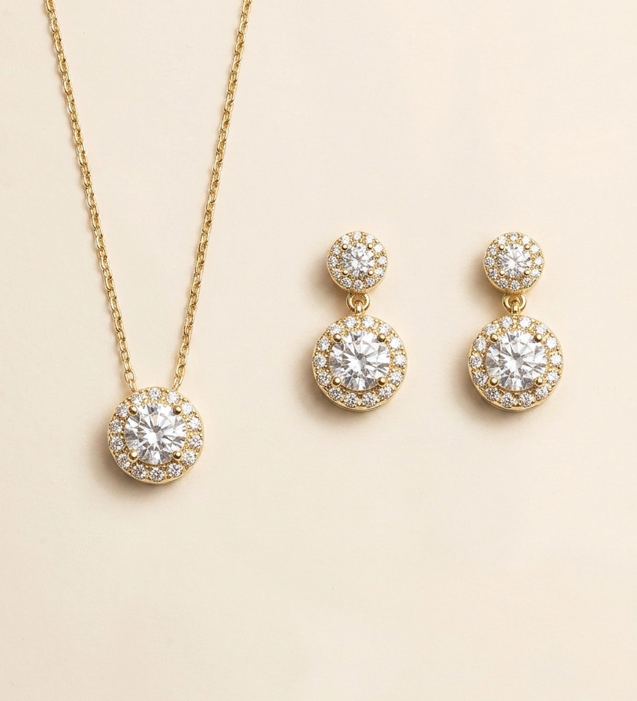 A gold necklace with a pendant and a pair of earrings with a similar design.