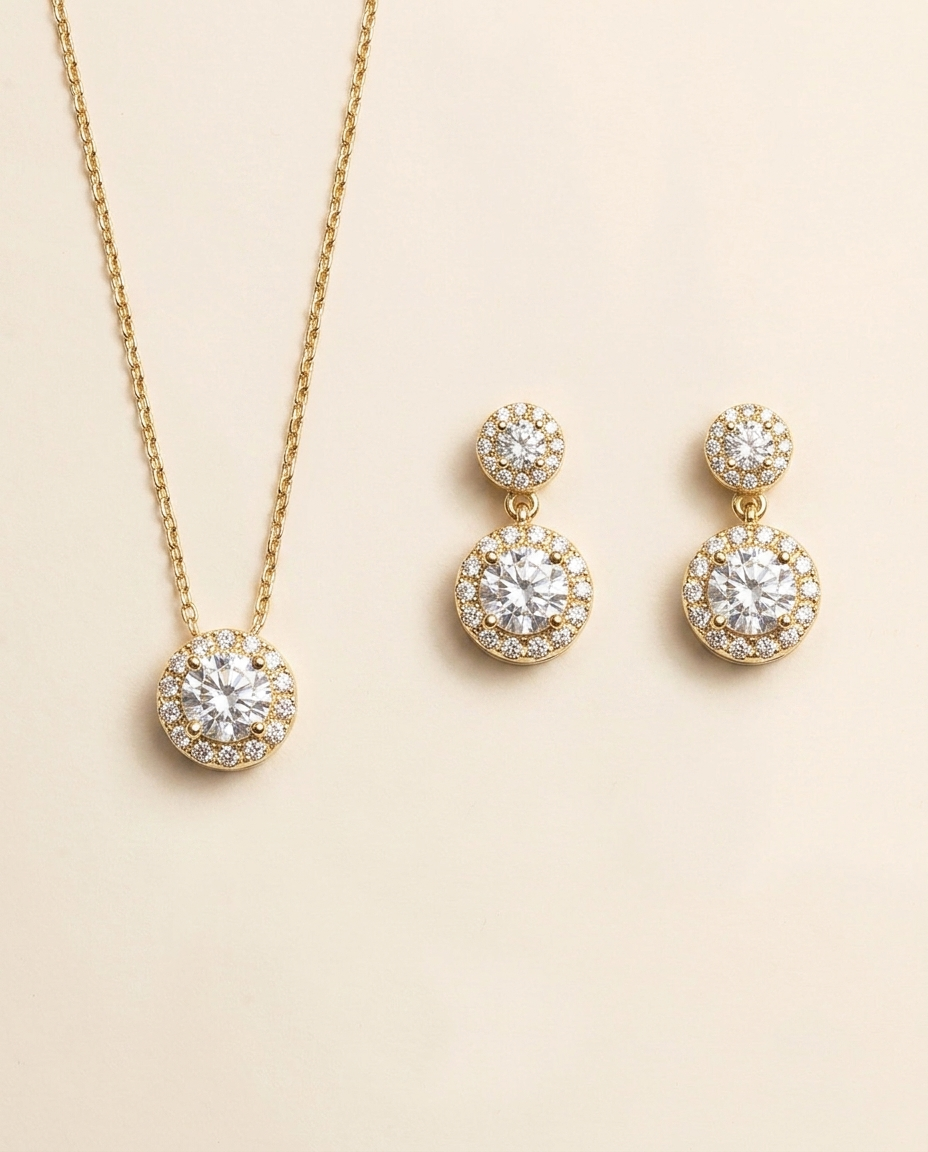 A gold necklace with a pendant and a pair of earrings with a similar design.