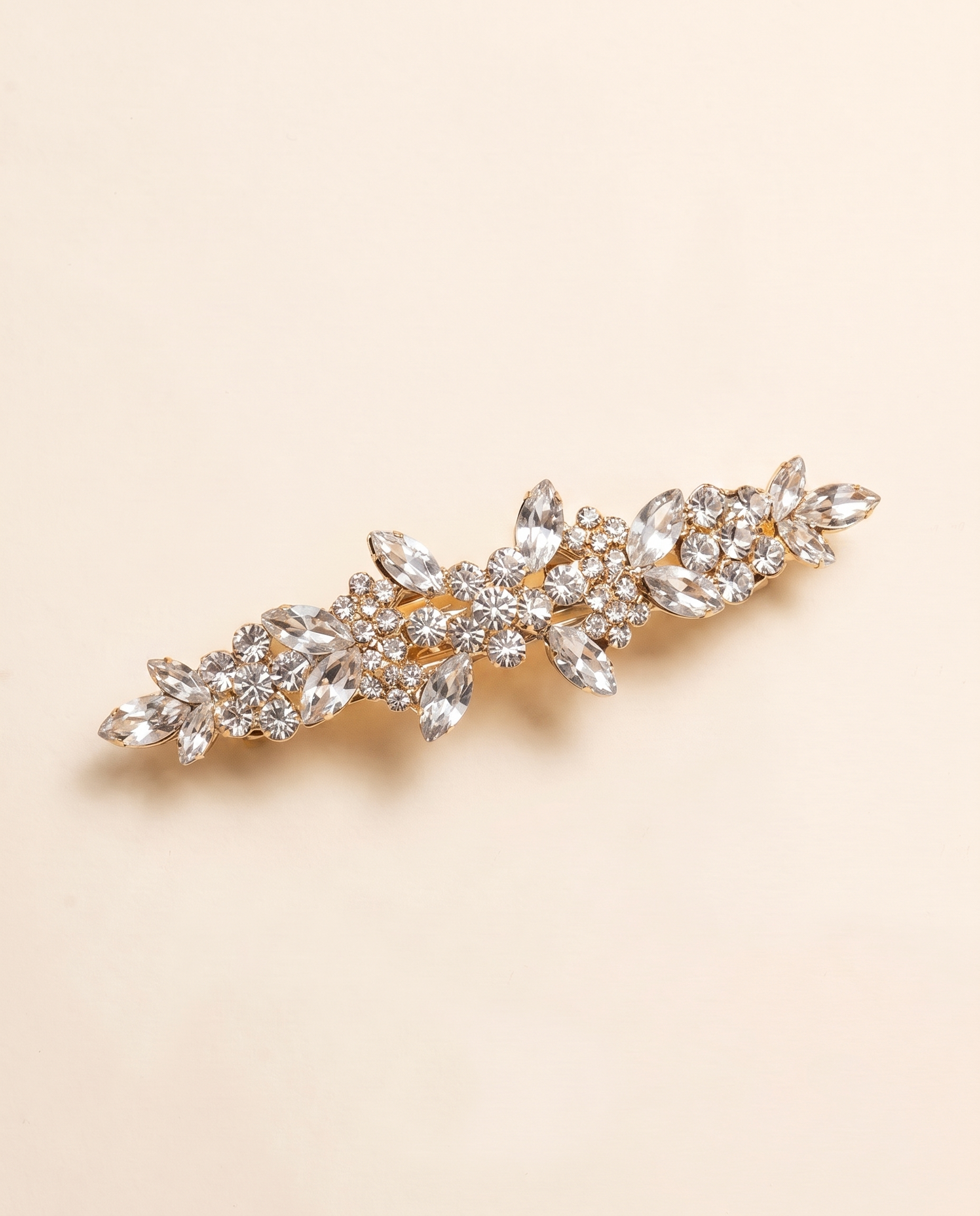 A decorative hair clip with a floral design and numerous small, clear gemstones.