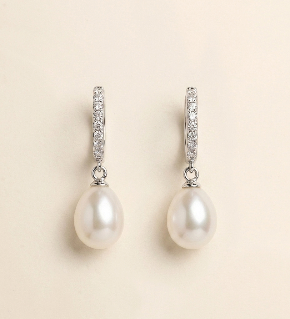 A pair of elegant earrings with a pearl and diamond design.