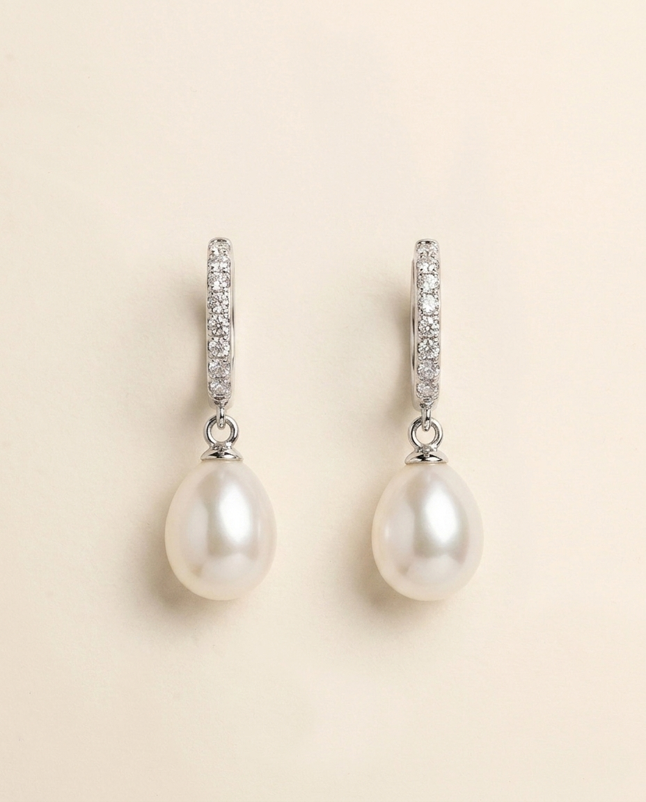 A pair of elegant earrings with a pearl and diamond design.