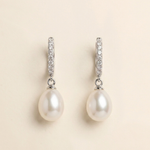 A pair of elegant earrings with a pearl and diamond design.