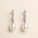 A pair of elegant earrings with a pearl and diamond design.