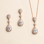 a set of elegant jewelry pieces, including earrings and a necklace, featuring a combination of pear-shaped and teardrop-shaped stones, as well as a chain.