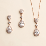a set of elegant jewelry pieces, including earrings and a necklace, featuring a combination of pear-shaped and teardrop-shaped stones, as well as a chain.