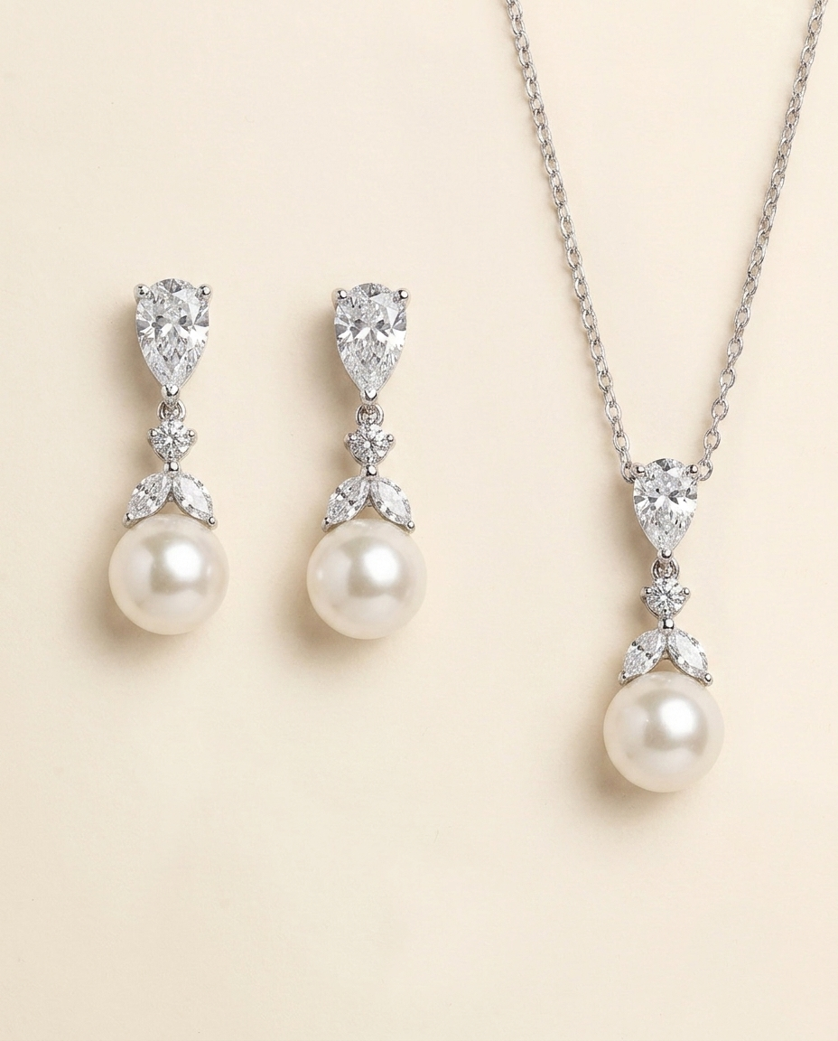 A necklace and earrings set featuring a pendant and earrings with pearls and diamonds.