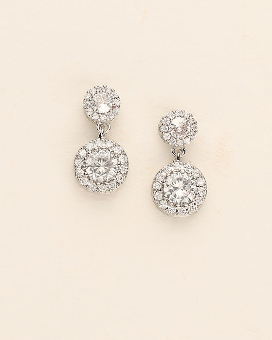 a pair of diamond earrings on a white background