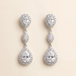 A pair of elegant earrings with a large central crystal surrounded by smaller pear-shaped and teardrop-shaped stones, all set in a silver-toned metal.
