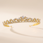 A gold tiara adorned with numerous small diamonds.