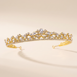 A gold tiara adorned with numerous small diamonds.