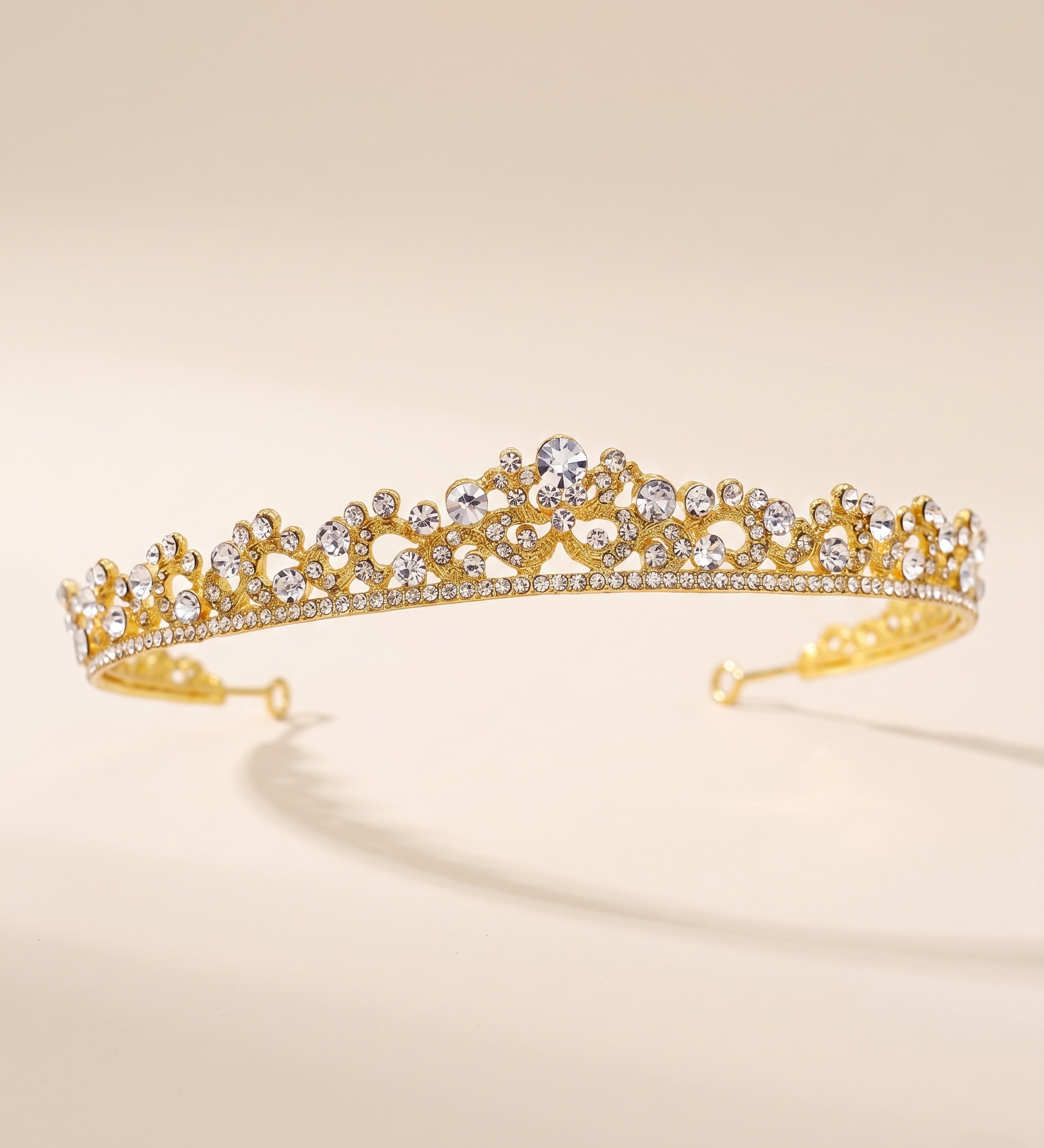 A gold tiara adorned with numerous small diamonds.