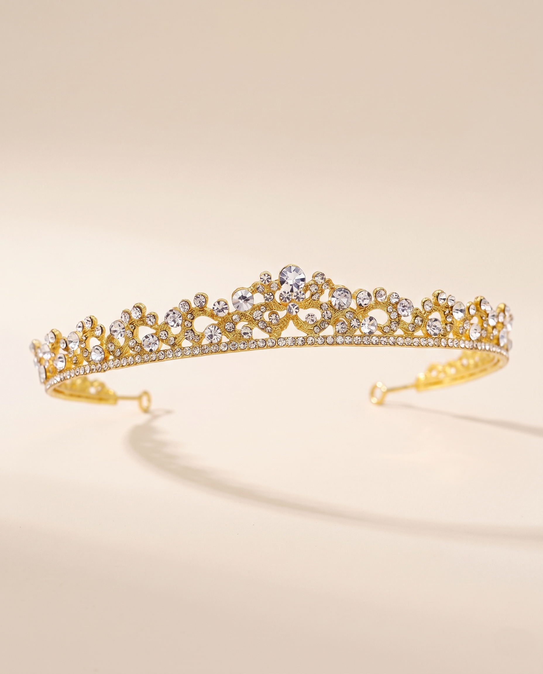 A gold tiara adorned with numerous small diamonds.