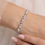 A close-up of a person's wrist wearing a bracelet with a row of small, clear gemstones.