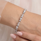 A close-up of a person's wrist wearing a bracelet with a row of small, clear gemstones.
