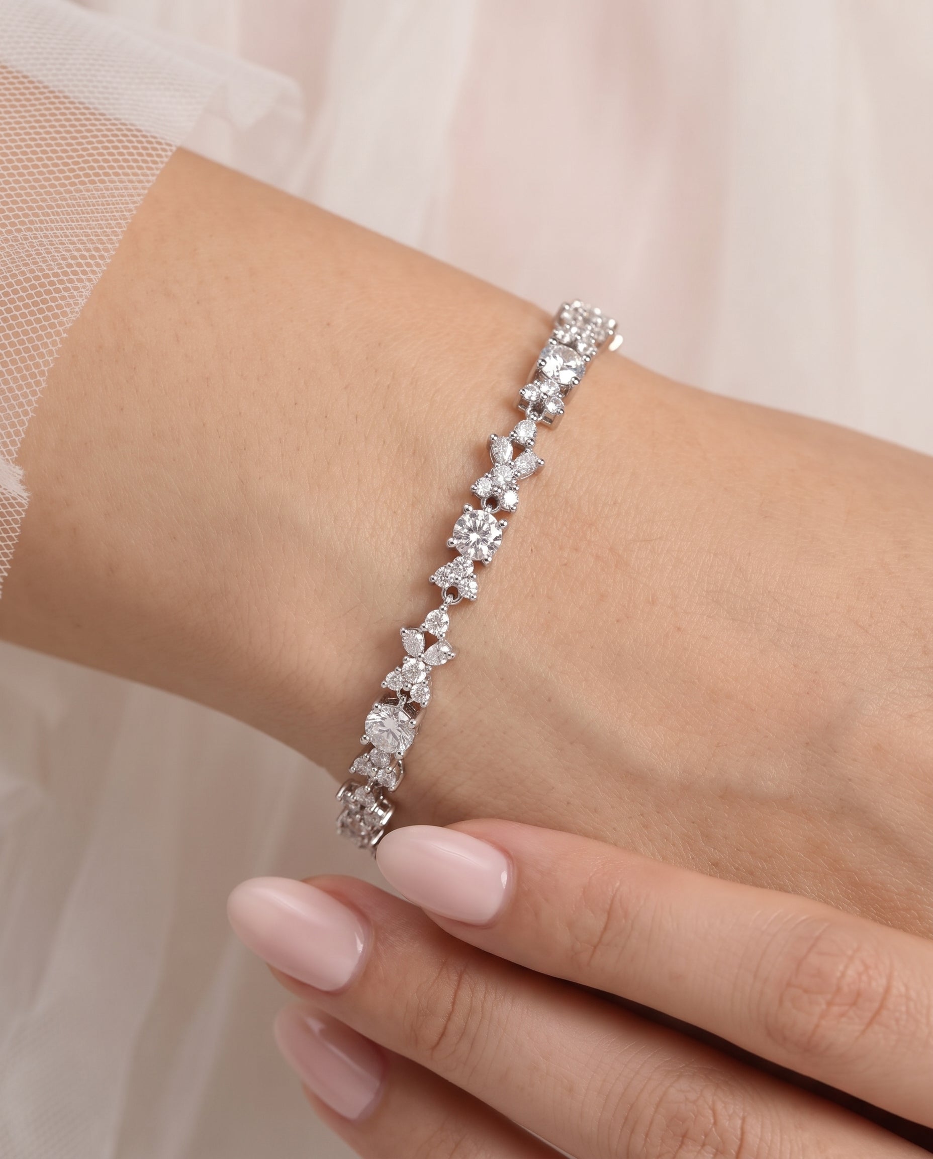 A close-up of a person's wrist wearing a bracelet with a row of small, clear gemstones.