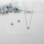 a necklace, earrings, and bracelet on a white surface