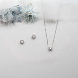 a necklace, earrings, and bracelet on a white surface