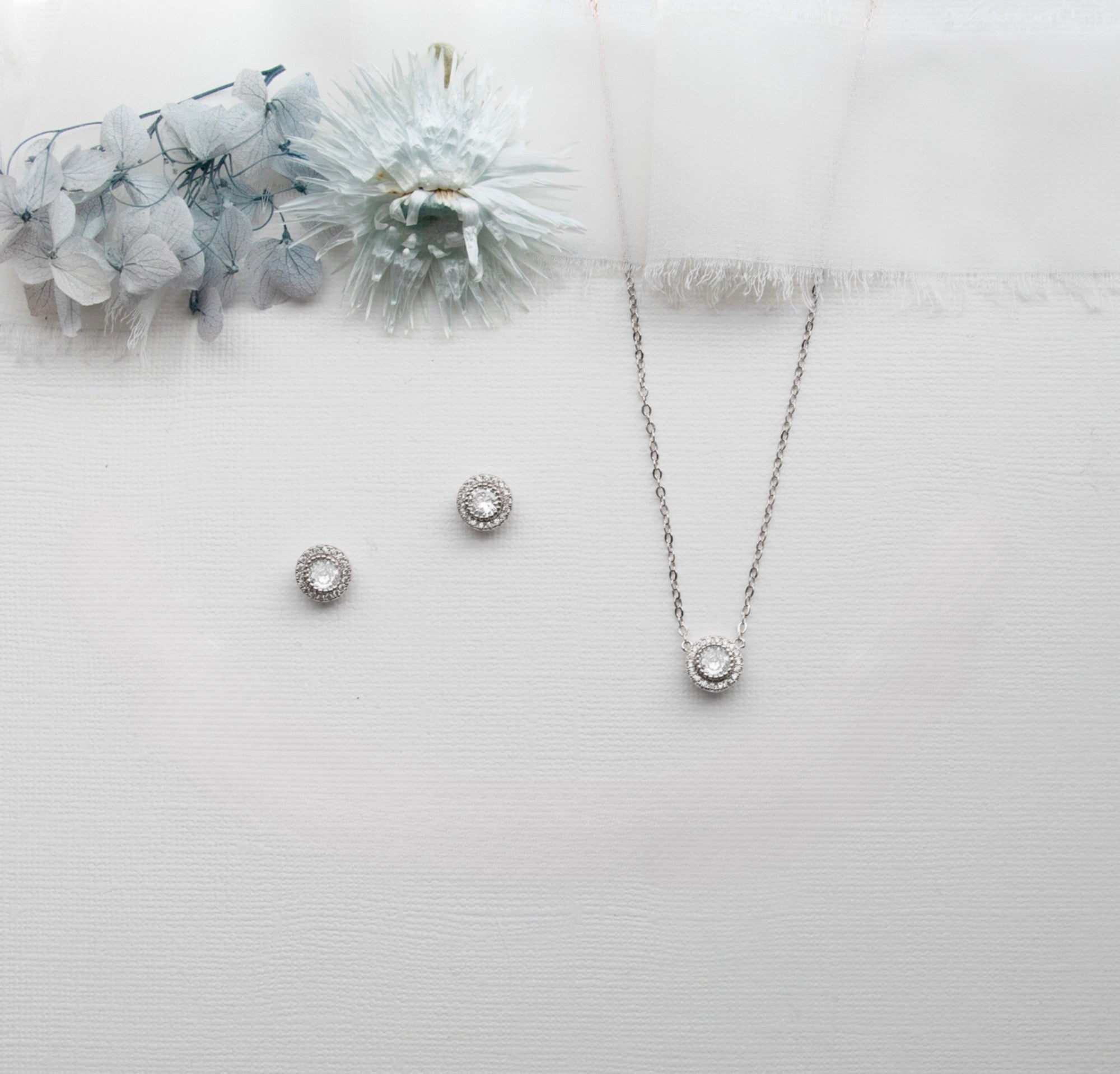 a necklace, earrings, and bracelet on a white surface