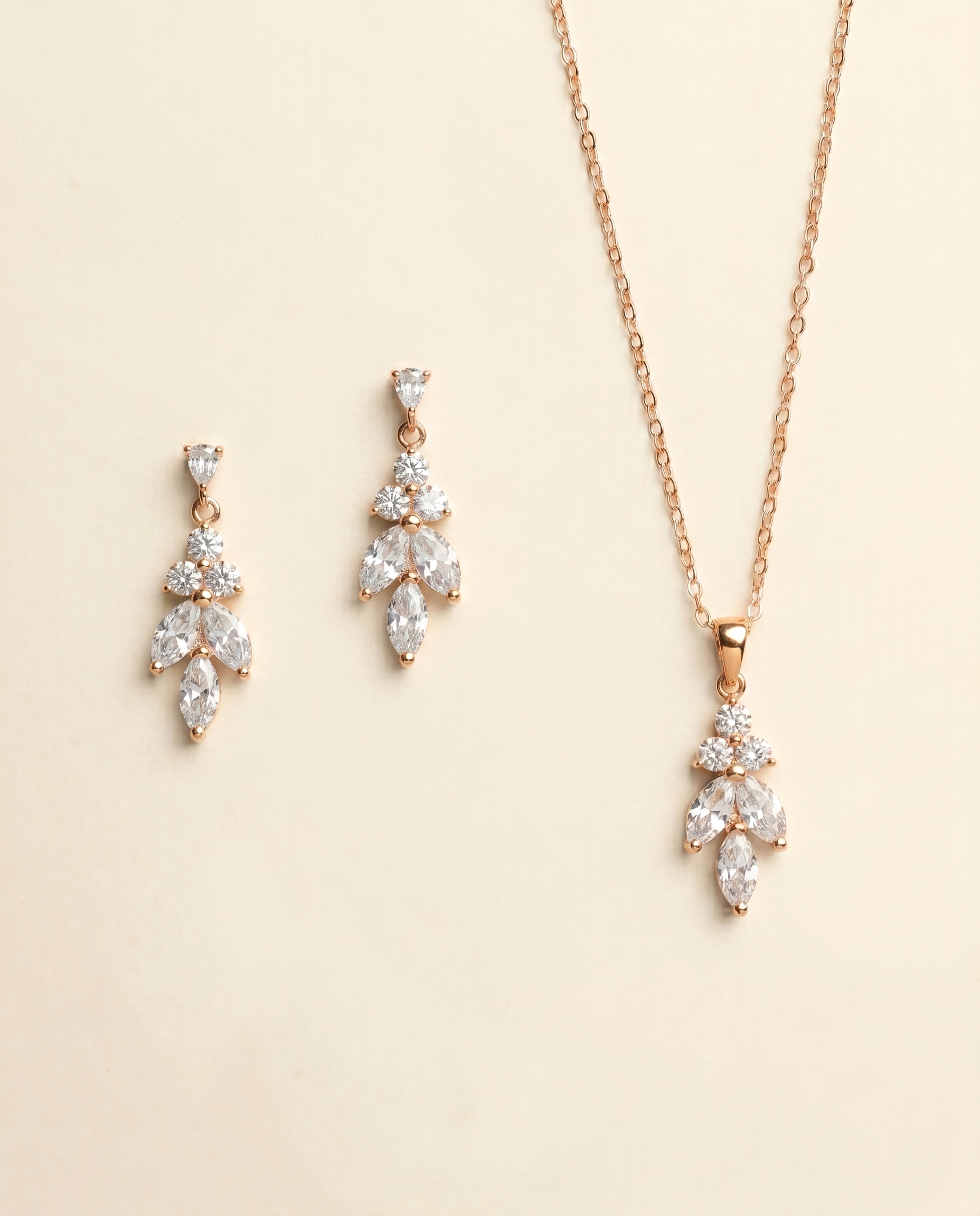 A necklace and earrings set made of gold and adorned with clear gemstones.