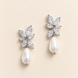 Pair of Gabriella silver-finish earrings with clear marquise floral clusters and white teardrop accents on an ivory background