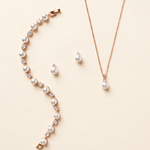 Jennifer rose gold pearl and crystal earrings, necklace and bracelet three-piece jewelry set on cream background