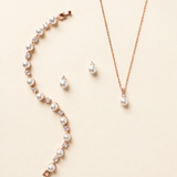 Jennifer rose gold pearl and crystal earrings, necklace and bracelet three-piece jewelry set on cream background