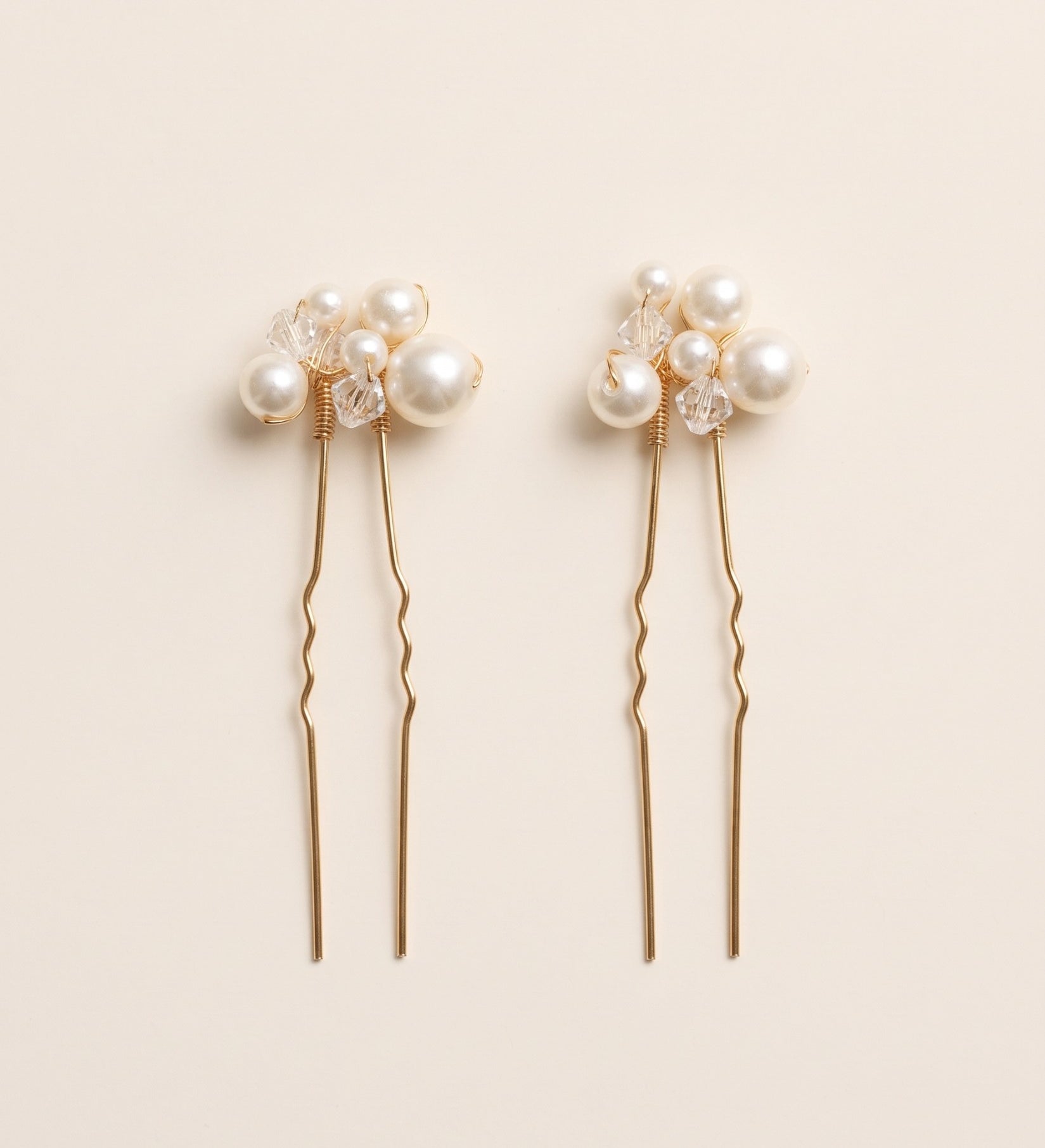 Two complete Mara pearl and crystal hair pins in gold.