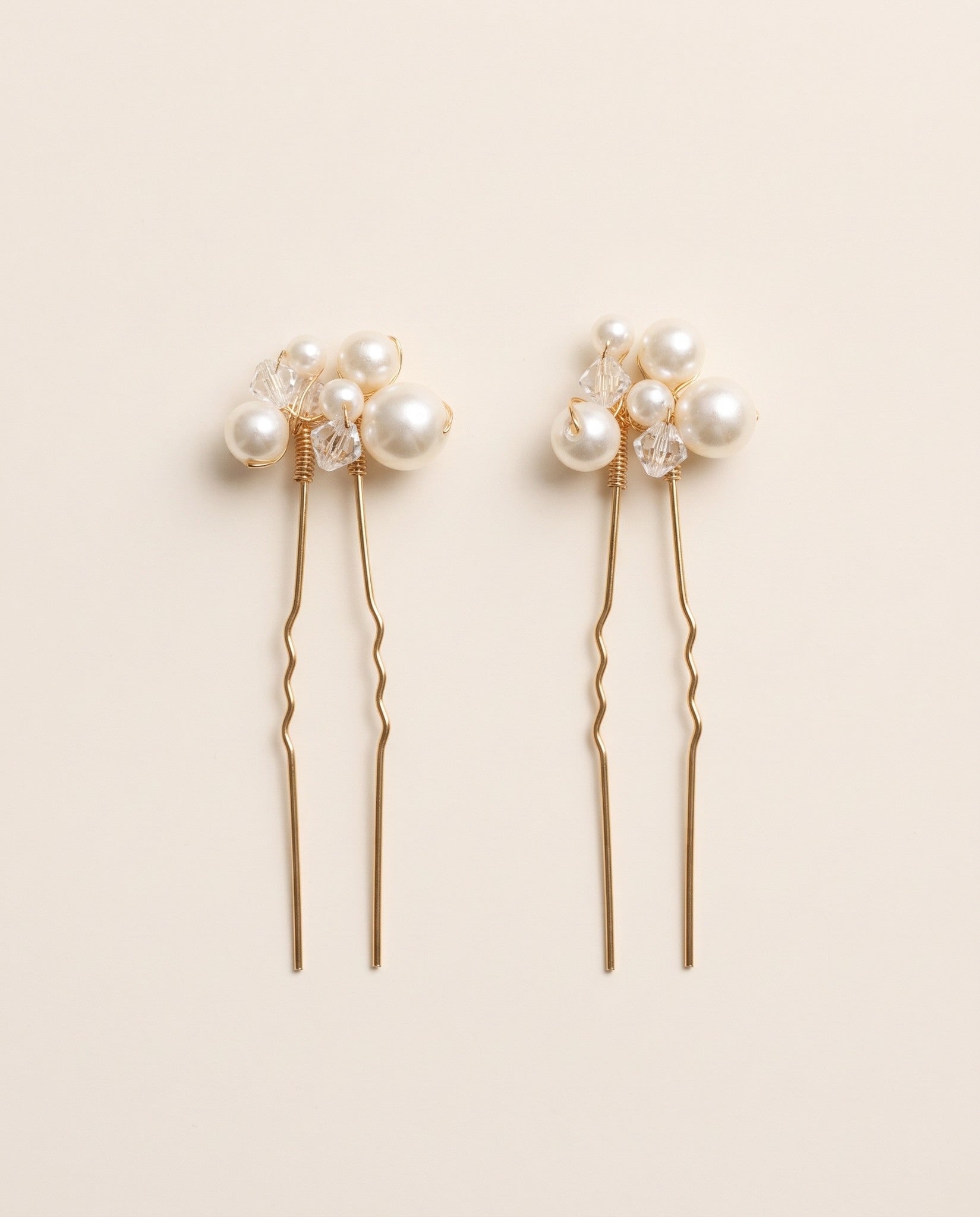 Two complete Mara pearl and crystal hair pins in gold.